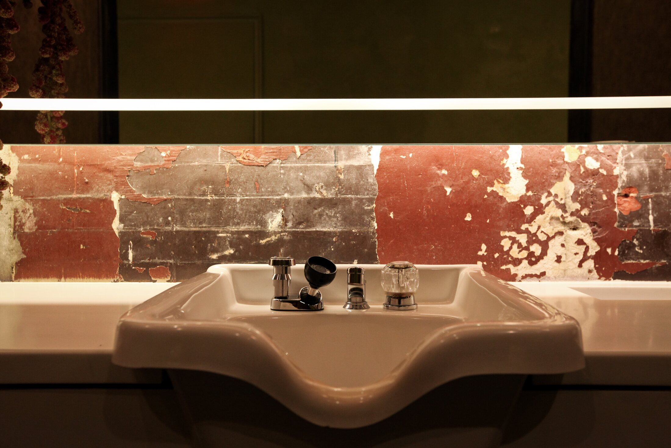 A wash basin and distressed-brick wall inside the Martial Vivot Midtown salon